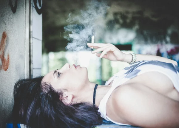 Frau raucht im Liegen